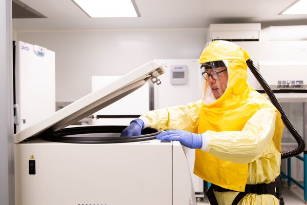man in biohazard suit in lab