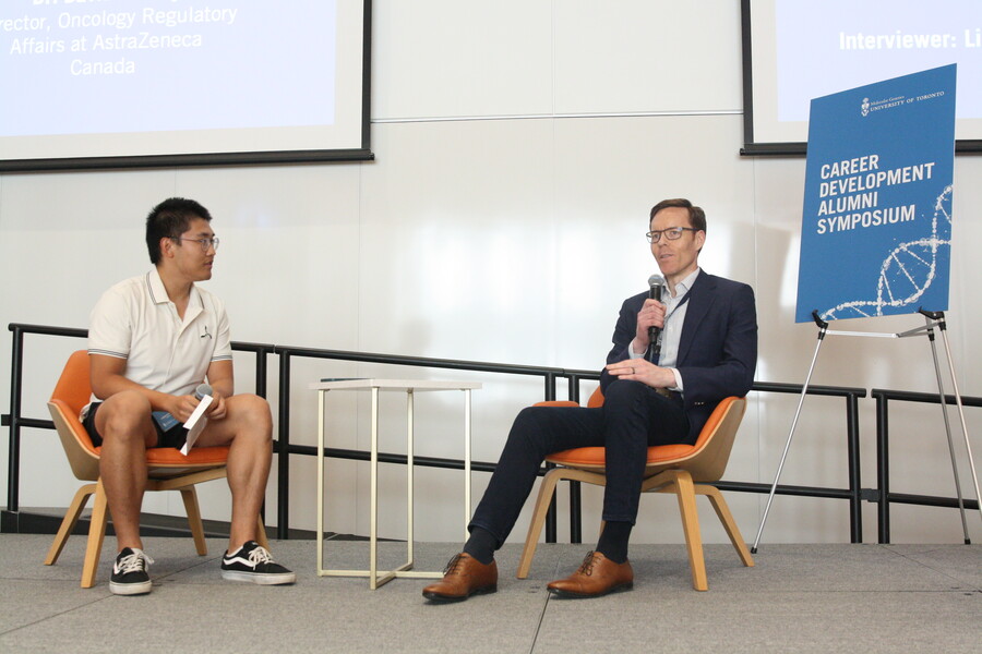 A student interviewer speaks with Dr. David Sealey on stage in front of an audience.
