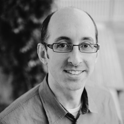 Gary Bader smiling with glasses in a black and white photo